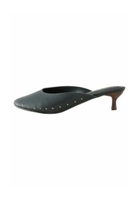 Mula de cuero negro con puntera afilada, tacón bajo de madera y detalles de tachuelas doradas a lo largo del borde. Textura suave y diseño elegante.