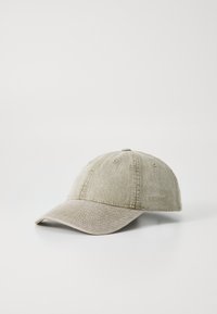 Cappello da baseball in cotone di un beige chiaro, con visiera curva, texture cucita e logo del brand sul lato. Cinghia regolabile sul retro.