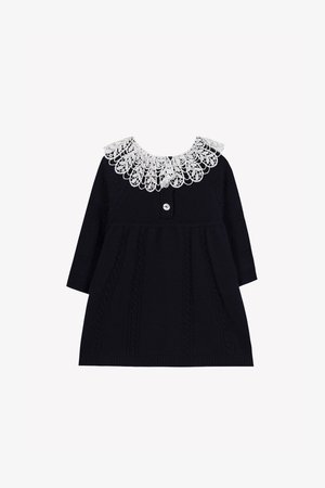 Rochie tricotată bleumarin cu mâneci lungi, având un guler decorativ din dantelă albă și o închidere cu buton în față. Detalii cu cabluri texturate.