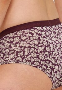 Chiloți cu un model floral burgund, având o bandă elastică lată. Materialul este neted, cu o textură ușoară, și prezintă mici desene cu flori albe.