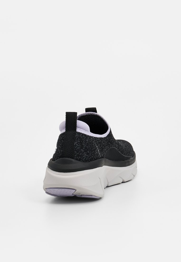 Schwarze Slipper-Sneaker mit strukturiertem Strickoberteil, kontrastierendem lavendelfarbenem Innenfutter und dicker weißer Zwischensohle mit helllila Akzenten.