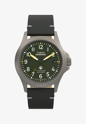 Timex Expedition sat s titanskim kućištem, zelenim brojčanikom, bijelim oznakama sati i crnom kožnom narukvicom. Ima žute naglaske i prikaz datuma.