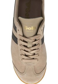 Sneaker in suede beige con strisce nere, punta arrotondata e design con lacci. Presenta il logo dorato sulla linguetta e lacci testurizzati.