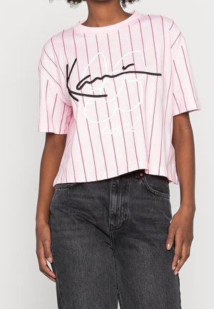 T-shirt a righe rosa con maniche corte, presenta una vestibilità morbida e un design grafico in bianco e nero con la scritta "POSSO?".
