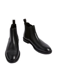 Botas Chelsea de cuero negro con paneles elásticos en los laterales, superficie lisa, punta redonda y tirador en el talón. Suela de goma resistente.