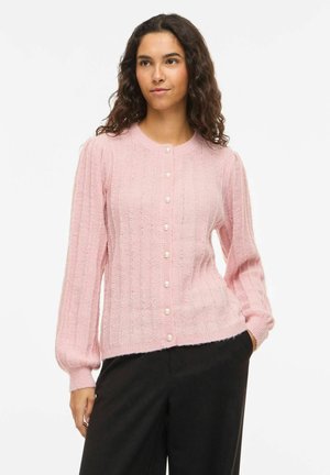 Cárdigan de punto color rosa claro con textura acanalada, escote redondo y botones de perla en la parte delantera. Presenta mangas largas abullonadas.