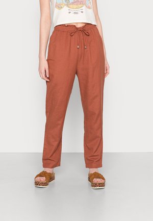 Linnen broek in roestkleur met een elastische taille en trekkoord, met een ruime pasvorm en taps toelopende pijpen, gecombineerd met bruine plateau sandalen.