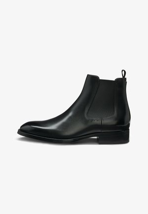 Svart läder Chelsea-boots med en slät yta, elastiska sidopaneler och en dragflik bak. Har en något spetsig tå och låg klack.