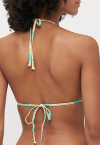 Bikini top with a multicolored geometric pattern, made of smooth fabric; features ties at the neck and back for adjustable fit.