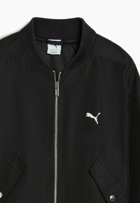 Veste bomber noire avec un col côtelé, une fermeture éclair argentée et deux poches latérales. Présente un logo Puma blanc sur la poitrine gauche.