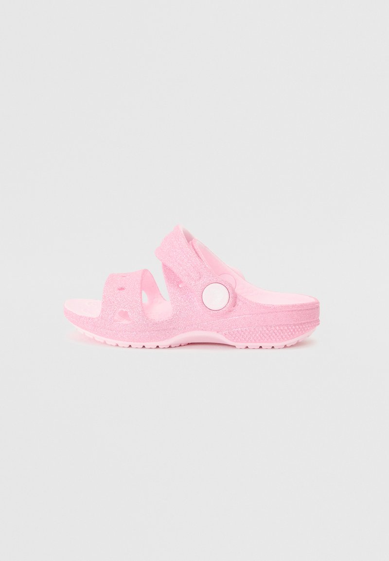 Pink glittery sandals with an open toe design and adjustable strap. Made of flexible material, featuring a textured sole for traction.