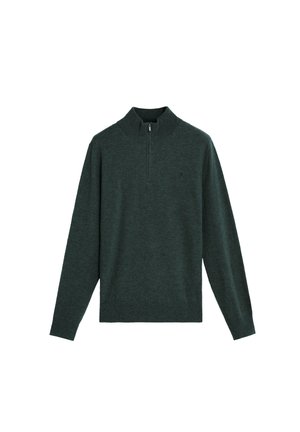 Pull-over en maille vert foncé avec un col montant et une fermeture éclair à mi-hauteur. Manches longues et coupe ajustée. Logo de marque discret sur la poitrine.