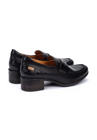 Mocasines de cuero negro con un patrón texturizado de cocodrilo, con un pequeño tacón y una etiqueta de marca. Interior suave con un diseño clásico.
