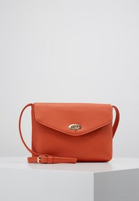 Orange leather crossbody bag with a textured finish, flap top, magnetic closure, and adjustable strap. Gold-tone hardware accents.