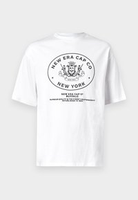 Hvid bomulds T-shirt med et sort cirkulært grafisk design, der har "New Era Cap Co" og et crest-design, samt tekst der fremhæver kvalitet siden 1920.