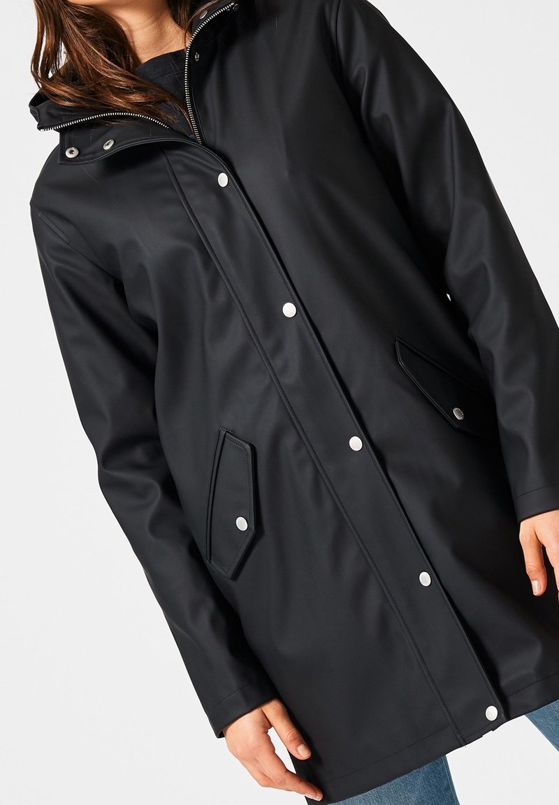 Svart vattentät jacka med huva, tryckknappsstängning, två vinklade framfickor och en slät, glänsande yta.