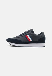Sneakers blu navy realizzati in suede e pelle, con strisce bianche, rosse e blu di lato e una suola bianca.