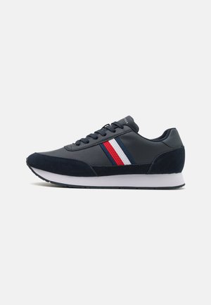 Sneakers blu navy realizzati in suede e pelle, con strisce bianche, rosse e blu di lato e una suola bianca.