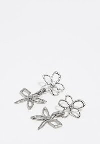 Pendientes florales de plata con dos diseños: una flor y una mariposa, con un acabado texturizado y un detalle central redondo.