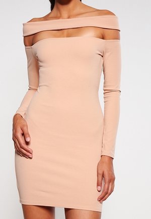 Robe moulante épaule dénudée, en beige clair, manches longues, texture lisse, longueur mi-cuisse avec un décolleté droit.