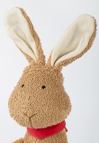 Stuffed rabbit made from textured brown fabric, featuring cream ears and a red scarf. Black stitched eyes and nose detail.