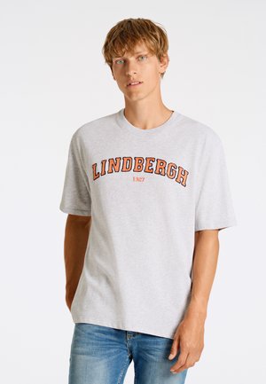 Camiseta de algodón gris con texto rojo y naranja "LINDBERGH 1927" en un patrón curvado en la parte frontal. Mangas cortas y cuello redondo.