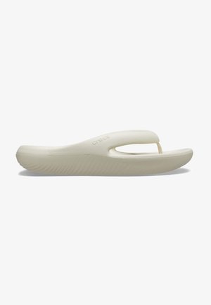 Sandale en mousse beige Crocs avec une semelle épaisse et un entre-doigts, conçue pour un usage décontracté et le confort.