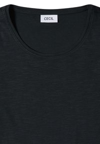 T-shirt noir col rond avec une étiquette rectangulaire blanche affichant "CECIL" cousue à l'intérieur du col.