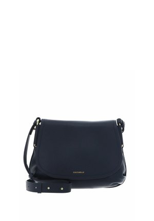 Sac bandoulière en cuir bleu marine avec fermeture à rabat, sangle réglable et petit logo doré "Coccinelle" sur le devant.