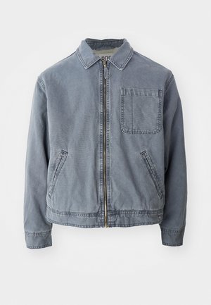 Jachetă din denim de culoare albastră estompată, cu guler, fermoar frontal și un buzunar pe piept. Are buzunare laterale și manșete elastice la tiv.