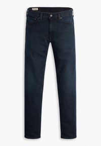 Jean slim bleu foncé en denim avec poches devant et derrière et fermeture par bouton à la taille sur fond blanc.