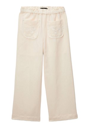 Pantalon large crème avec taille élastique et deux poches avant ornées de broderies florales et de bordures en dentelle.