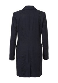 Manteau bleu marine avec un motif texturé, coupe ajustée, fente unique au dos et revers crantés. Manches longues et poches latérales.