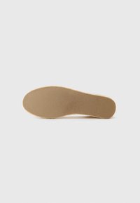 Schoeninlegzool met een textuur van beige rubber aan de onderkant. De vorm is gevormd met een ronde teen en een glad, gevoerd oppervlak.