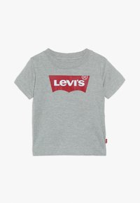 Camiseta de algodón gris con un gran logo rojo de "Levi's" en letras blancas, mangas cortas y cuello redondo. Etiqueta en el costado.