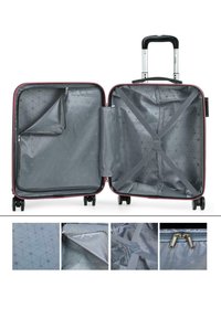 Maleta rígida con exterior rojo e interior gris; cuenta con correas cruzadas, un bolsillo con cremallera y forro con patrón geométrico. Cuatro ruedas.