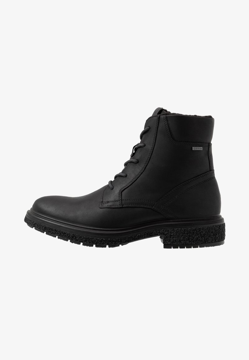 Bottine noire en cuir avec laçage à l’avant, semelle en caoutchouc texturée, col rembourré et petite étiquette Gore-Tex sur le côté.