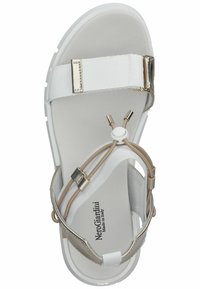 Sandalo bianco con suola testurizzata, dotato di una ampia fascia in tessuto e dettagli intrecciati in beige e hardware dorato. Logo del marchio visibile.