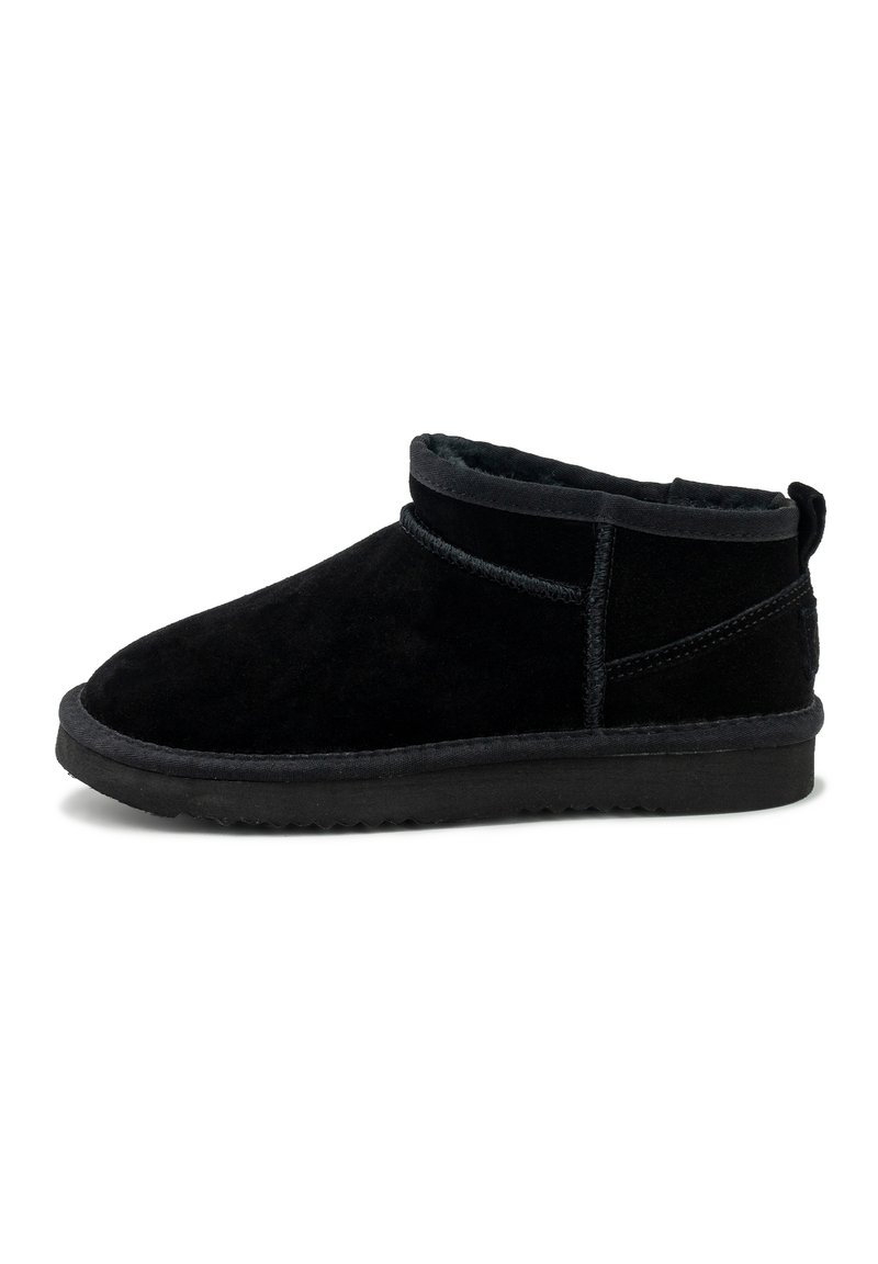Botas de tobillo de ante negro con un suave forro interior, punta redonda y una suela de perfil bajo. Presenta una costura cosida y una lengüeta en la parte trasera.