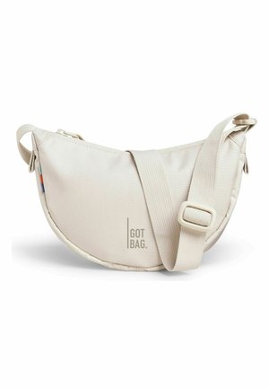 Beige half-moon shaped crossbody bag with adjustable strap and minimal text "GOT BAG" on front, set against white background.