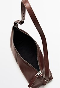 Sac bandoulière en cuir marron avec une fermeture éclair argentée, une sangle réglable et un compartiment principal ouvert montrant une doublure intérieure noire.