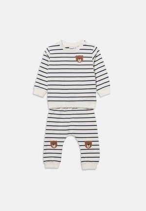 Hvit babyklær med marineblå horisontale striper, med brune bjørneansikter på brystet og knærne, med lange ermer og elastiske mansjetter og midje.