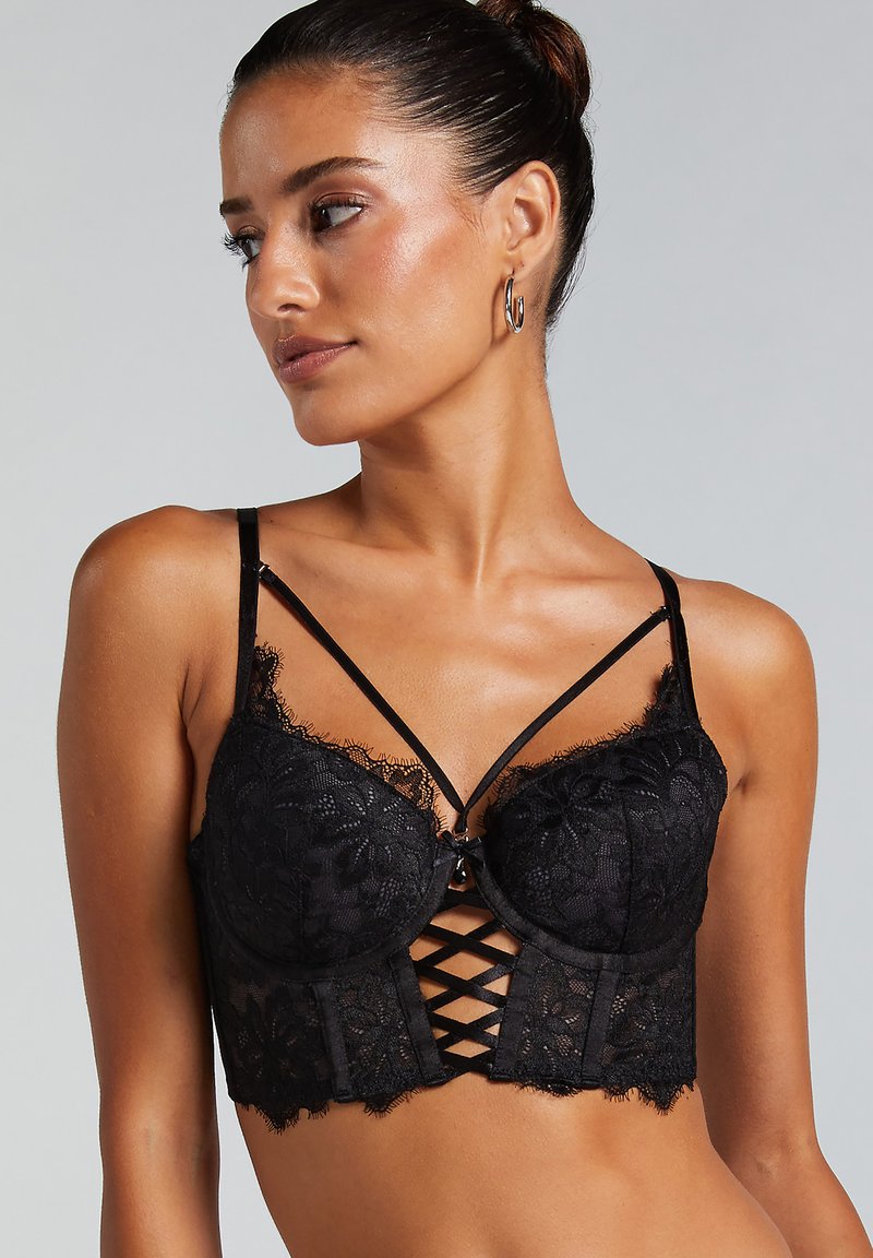 Black lace bra with underwire cups, semi-sheer fabric, and crisscross detail at the front. Features adjustable straps and lace trim.