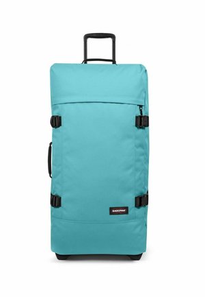 Sac de voyage turquoise à roulettes avec une poignée rétractable, des ferrures noires et des boucles latérales. Fabriqué en tissu durable avec une texture lisse.