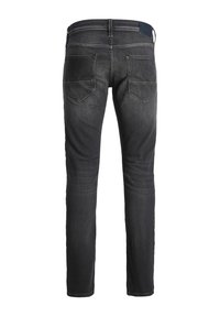 Jeans de mezclilla negra, de corte ajustado, con una textura suave, dos bolsillos traseros y un parche de cuero azul en la cintura.