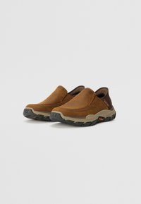 Smeđe kožne cipele na slip-on s odživljenim dizajnom, s udobnim smeškim srednjim soleom i crnim gumiranim vanjskim soleom s uzorkom.