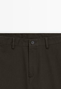 Pantalon brun foncé avec fermeture à boutons, passants de ceinture et une ceinture plate, vu de face au niveau de la taille.