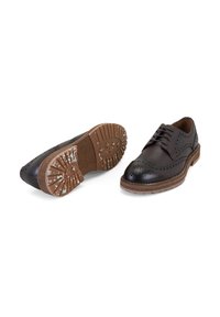 Chaussures oxford en cuir marron avec des perforations, embout noir et semelle en caoutchouc texturée marron ; comprenant des lacets et une forme arrondie.