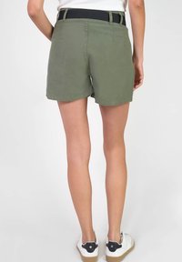 Shorts vert olive avec un devant plat, des passants de ceinture et une taille noire. Tissu lisse avec une texture subtile, coupés au-dessus du genou.