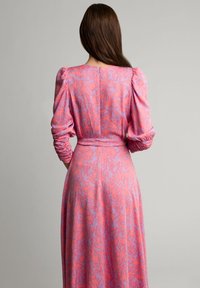 Sukienka z długim rękawem z miękkiej, elastycznej tkaniny, w różowo-fioletowy abstrakcyjny wzór, z zebranymi rękawami i dopasowaną talią.